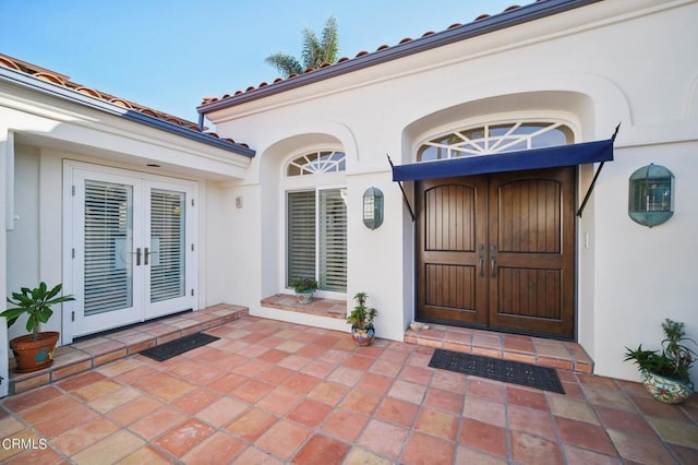 property entrance featuring a patio area, french doors, and stucco siding