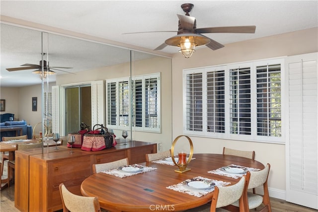 dining area with a textured ceiling, wood-type flooring, and ceiling fan