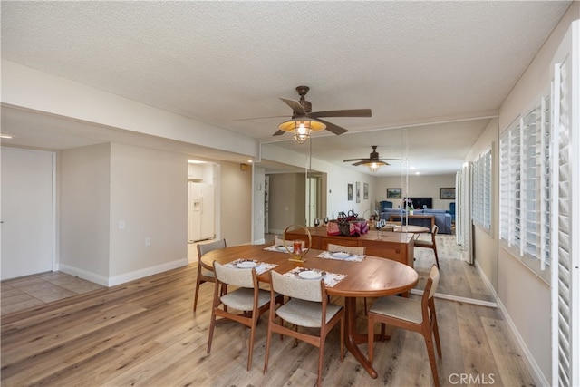 dining area with ceiling fan, a textured ceiling, and light hardwood / wood-style floors