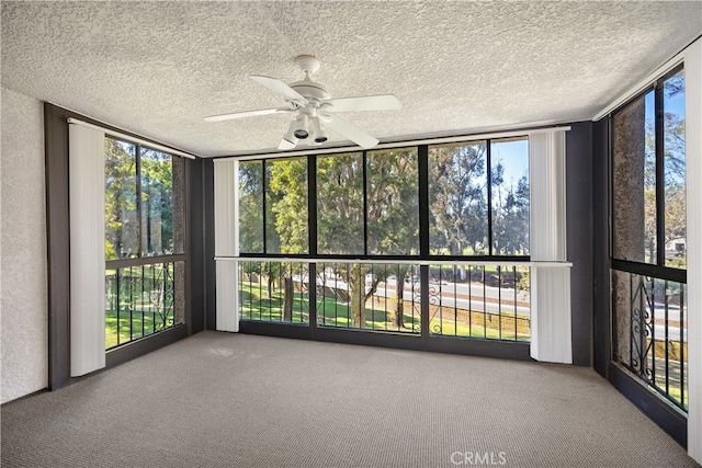 unfurnished sunroom featuring ceiling fan and a healthy amount of sunlight