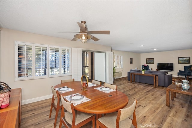 dining area with a textured ceiling, ceiling fan, and light hardwood / wood-style flooring