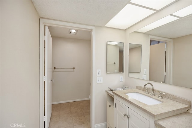 bathroom featuring a textured ceiling, tile patterned flooring, vanity, and toilet