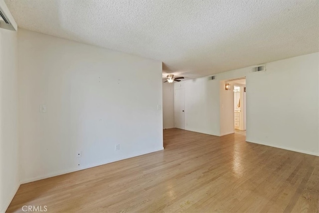 empty room featuring light wood-type flooring, a textured ceiling, and ceiling fan