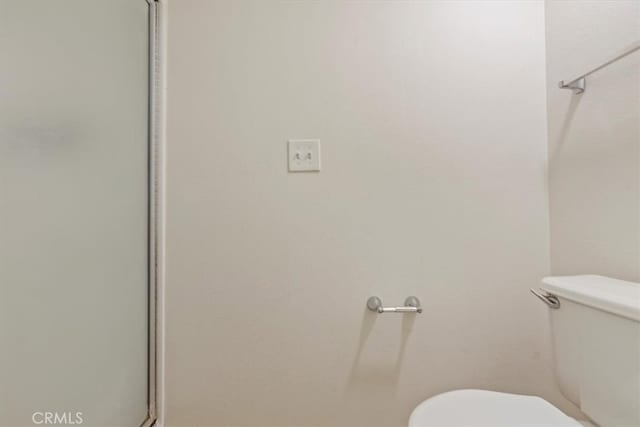 bathroom with walk in shower and toilet