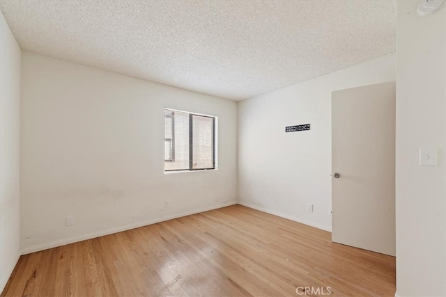 unfurnished room featuring light hardwood / wood-style floors and a textured ceiling