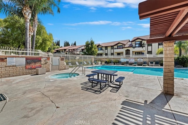 view of swimming pool with a patio and a hot tub