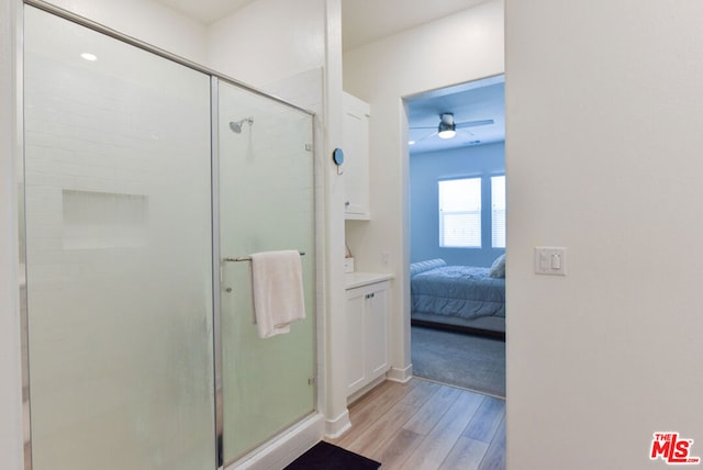 bathroom featuring wood-type flooring, an enclosed shower, and ceiling fan