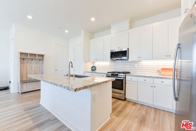 kitchen with sink, light hardwood / wood-style flooring, a kitchen island with sink, white cabinetry, and stainless steel appliances