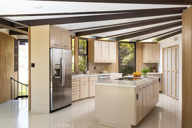 kitchen featuring appliances with stainless steel finishes, a center island, tasteful backsplash, sink, and vaulted ceiling