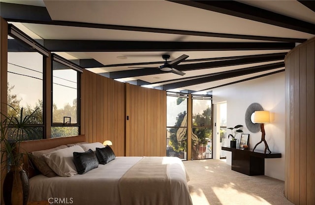 bedroom with carpet, multiple windows, wooden walls, and ceiling fan