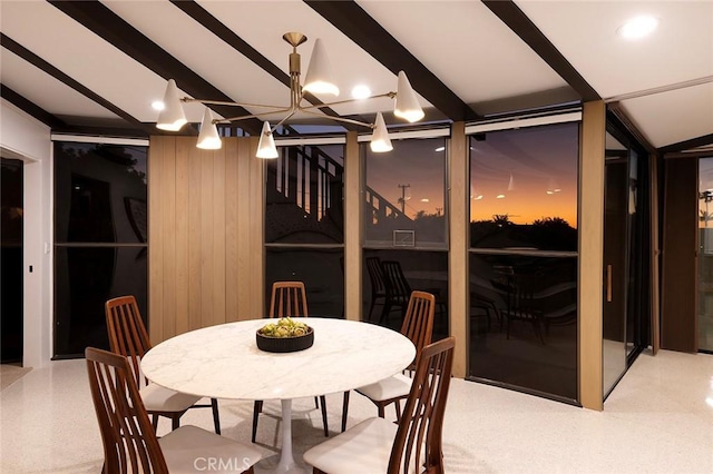 dining space featuring wood walls and floor to ceiling windows