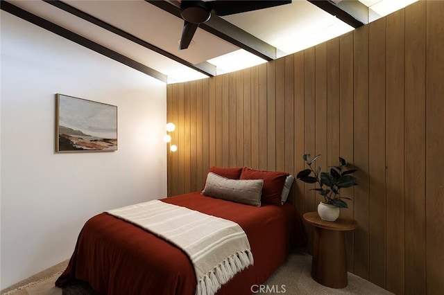 carpeted bedroom with lofted ceiling with beams, wooden walls, and ceiling fan