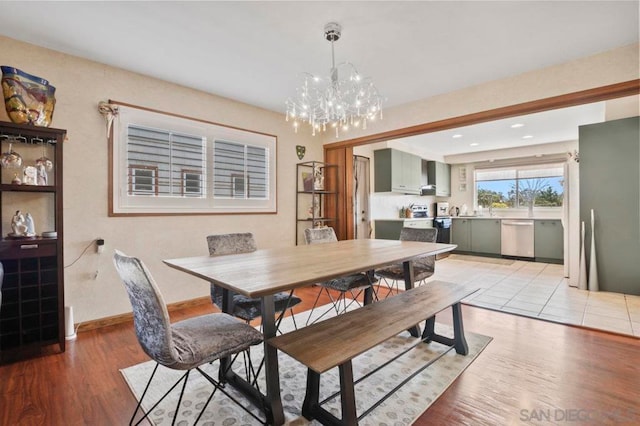 dining area featuring light wood-type flooring and a chandelier