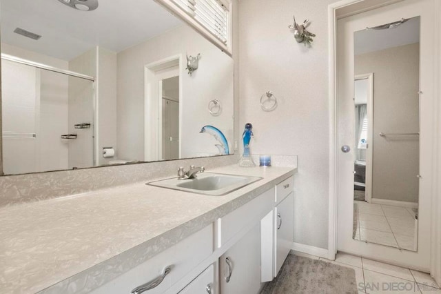 bathroom featuring tile patterned floors, an enclosed shower, and vanity