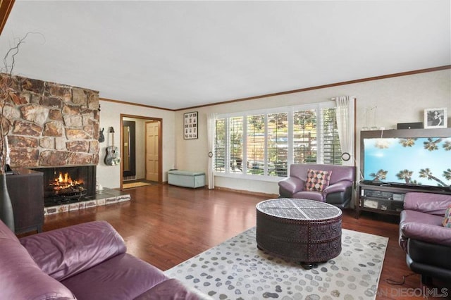 living room with crown molding, dark wood-type flooring, and a stone fireplace