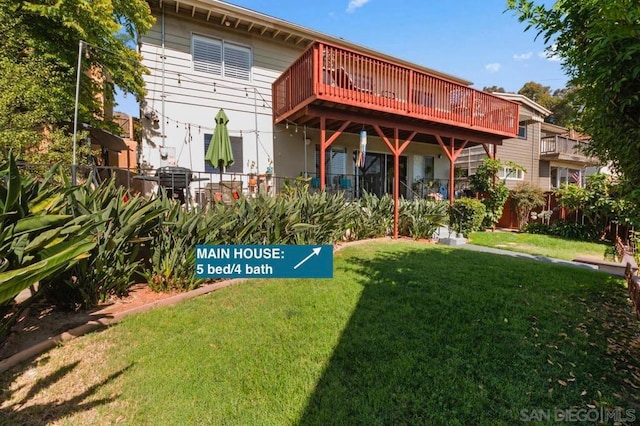 back of property featuring a wooden deck and a yard