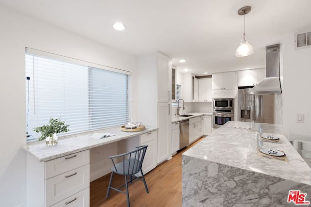 kitchen featuring white cabinetry, pendant lighting, stainless steel appliances, and ventilation hood