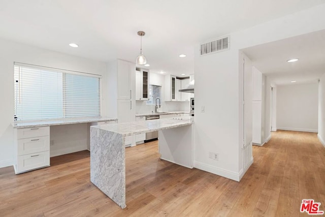 kitchen with white cabinetry, sink, dishwasher, light hardwood / wood-style flooring, and pendant lighting