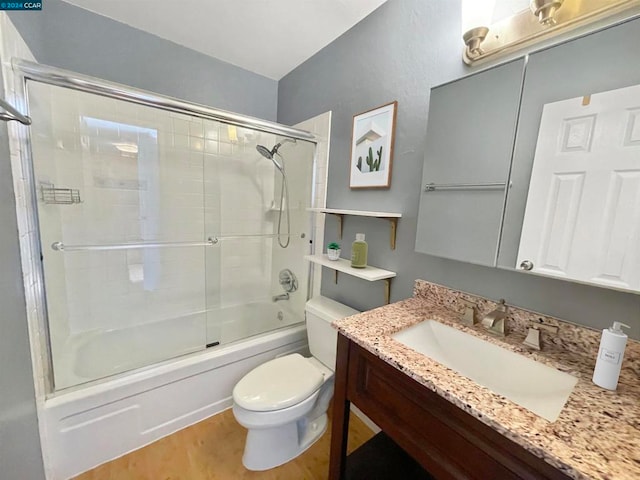 full bathroom featuring enclosed tub / shower combo, vanity, and toilet