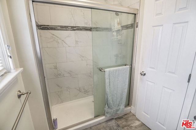 bathroom featuring a shower with door and hardwood / wood-style flooring