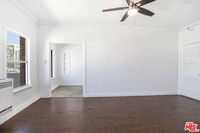 unfurnished room with ornamental molding, heating unit, and dark wood-type flooring