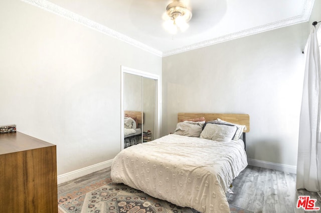 bedroom with crown molding, hardwood / wood-style floors, and ceiling fan