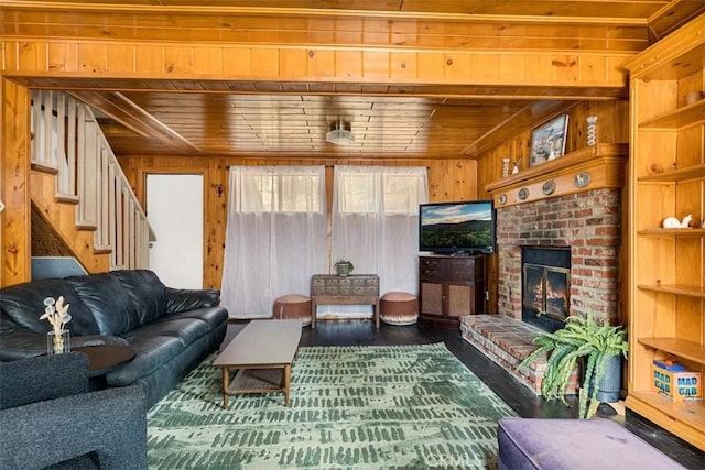 living room with wood walls, wood ceiling, and a fireplace