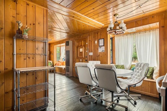 dining space with wood walls, wood ceiling, plenty of natural light, and an inviting chandelier