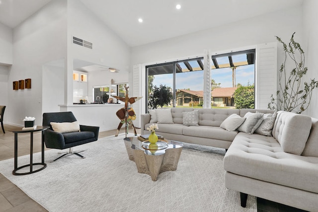 living room with light hardwood / wood-style flooring and high vaulted ceiling