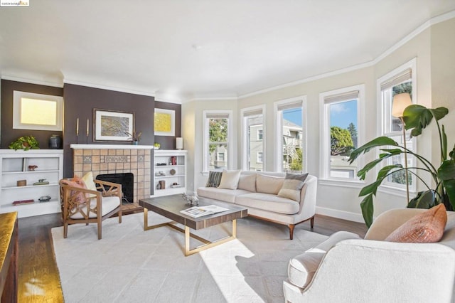 living room with a tile fireplace, light hardwood / wood-style floors, and crown molding