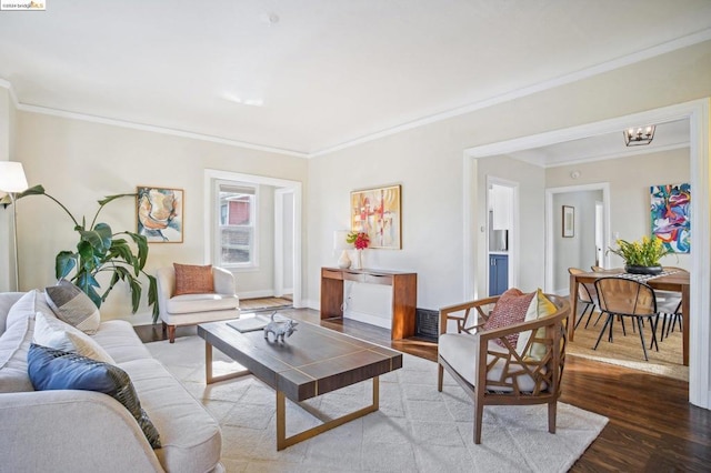 living room featuring hardwood / wood-style floors, an inviting chandelier, and ornamental molding