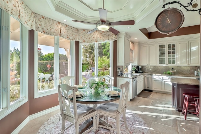 sunroom / solarium with a tray ceiling and ceiling fan