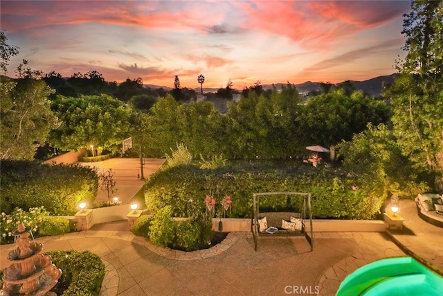 patio terrace at dusk featuring a mountain view