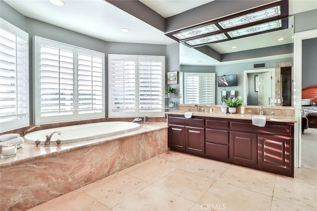 bathroom with tile patterned floors, tiled bath, and vanity