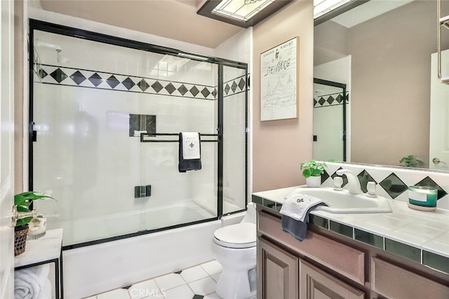 full bathroom with tile patterned flooring, vanity, toilet, and bath / shower combo with glass door