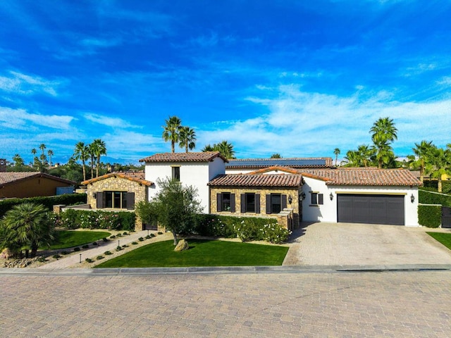 mediterranean / spanish-style house featuring a garage and a front lawn