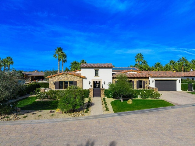 mediterranean / spanish-style house with a garage and a front lawn