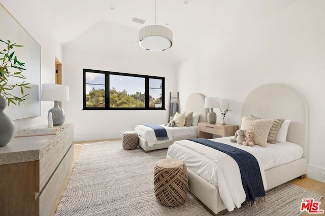 bedroom featuring light hardwood / wood-style flooring and lofted ceiling