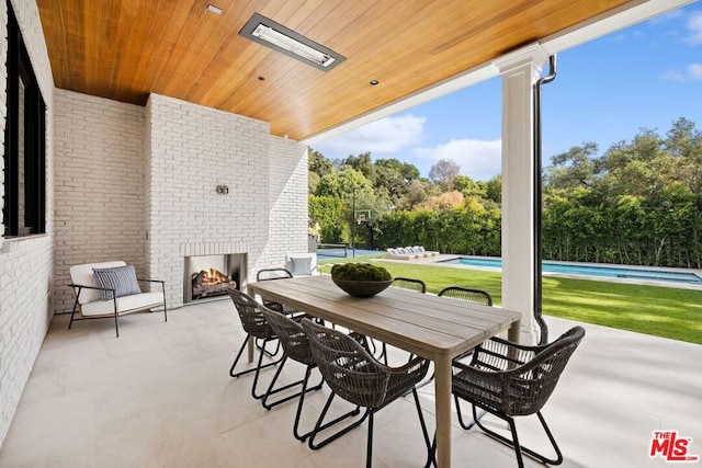 view of patio featuring an outdoor brick fireplace