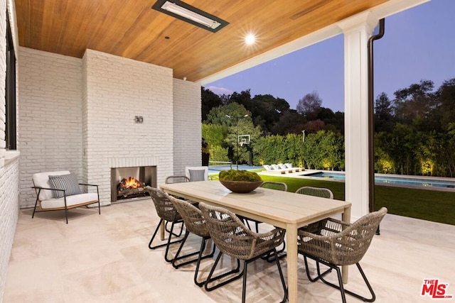 patio terrace at dusk with an outdoor brick fireplace