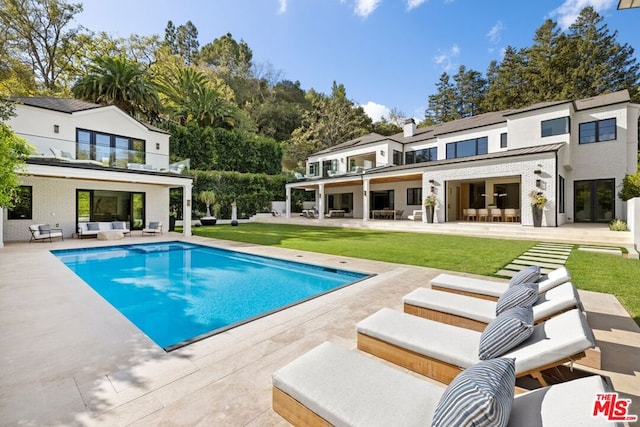 view of pool with a lawn, outdoor lounge area, and a patio