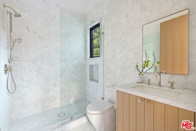 bathroom with vanity, toilet, tile walls, tasteful backsplash, and a tile shower