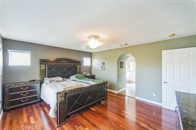 bedroom with multiple windows and dark hardwood / wood-style flooring