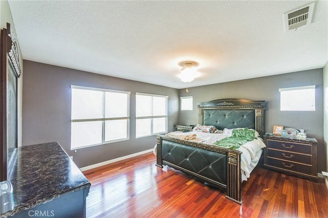 bedroom featuring a textured ceiling and dark wood-type flooring