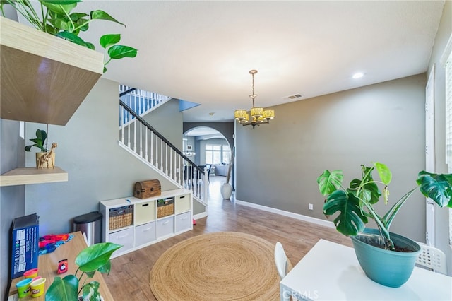 rec room featuring wood-type flooring and a chandelier