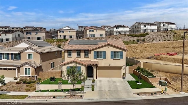 view of front of property featuring solar panels and a garage