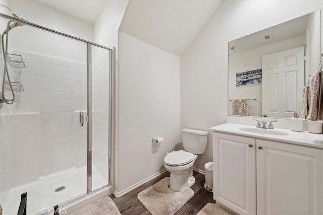 bathroom with vaulted ceiling, toilet, a shower with door, vanity, and hardwood / wood-style flooring