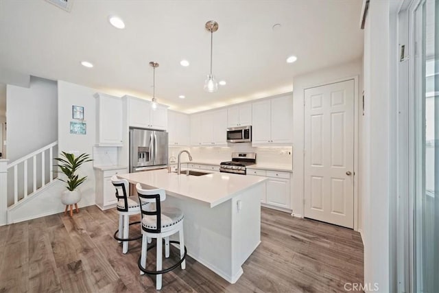 kitchen featuring white cabinets, sink, light wood-type flooring, and stainless steel appliances