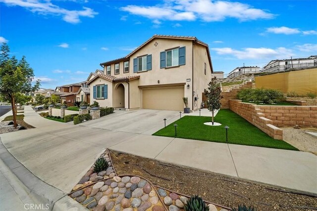 mediterranean / spanish-style house featuring a front lawn and a garage