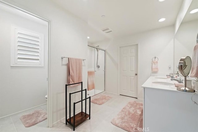 bathroom featuring tile patterned flooring, a shower with door, vanity, and toilet